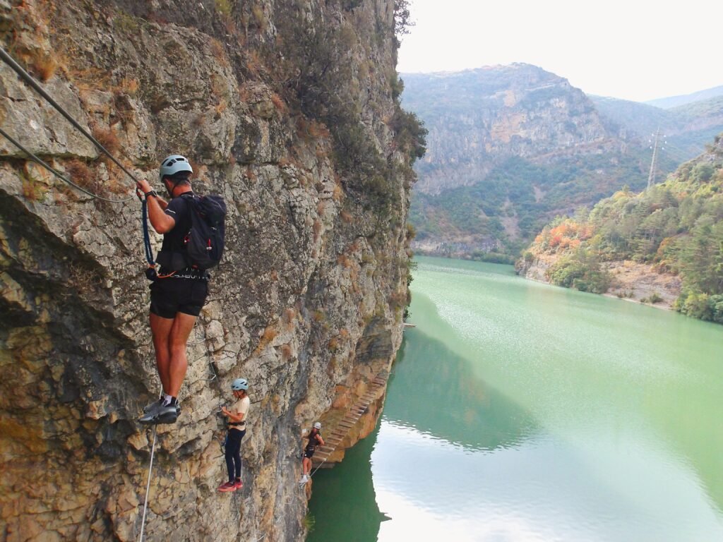 chico cruzando el puente y más personas en la vía ferrata paret de les arcades en la pobla de segur, el Pallars Jussà, Pirineos catalanes