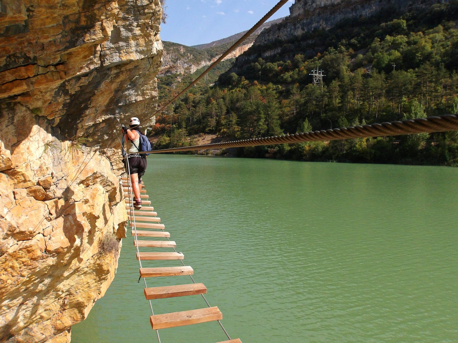 Chica cruzando el puente de la vía ferrata paret de les arcades