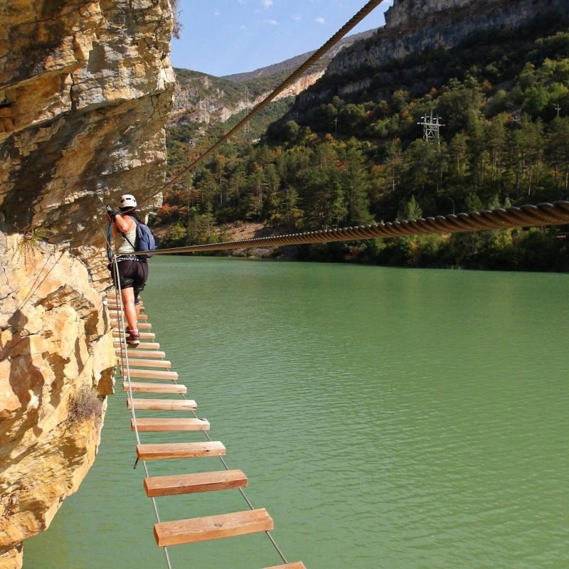 Chica cruzando el puente de la vía ferrata paret de les arcades